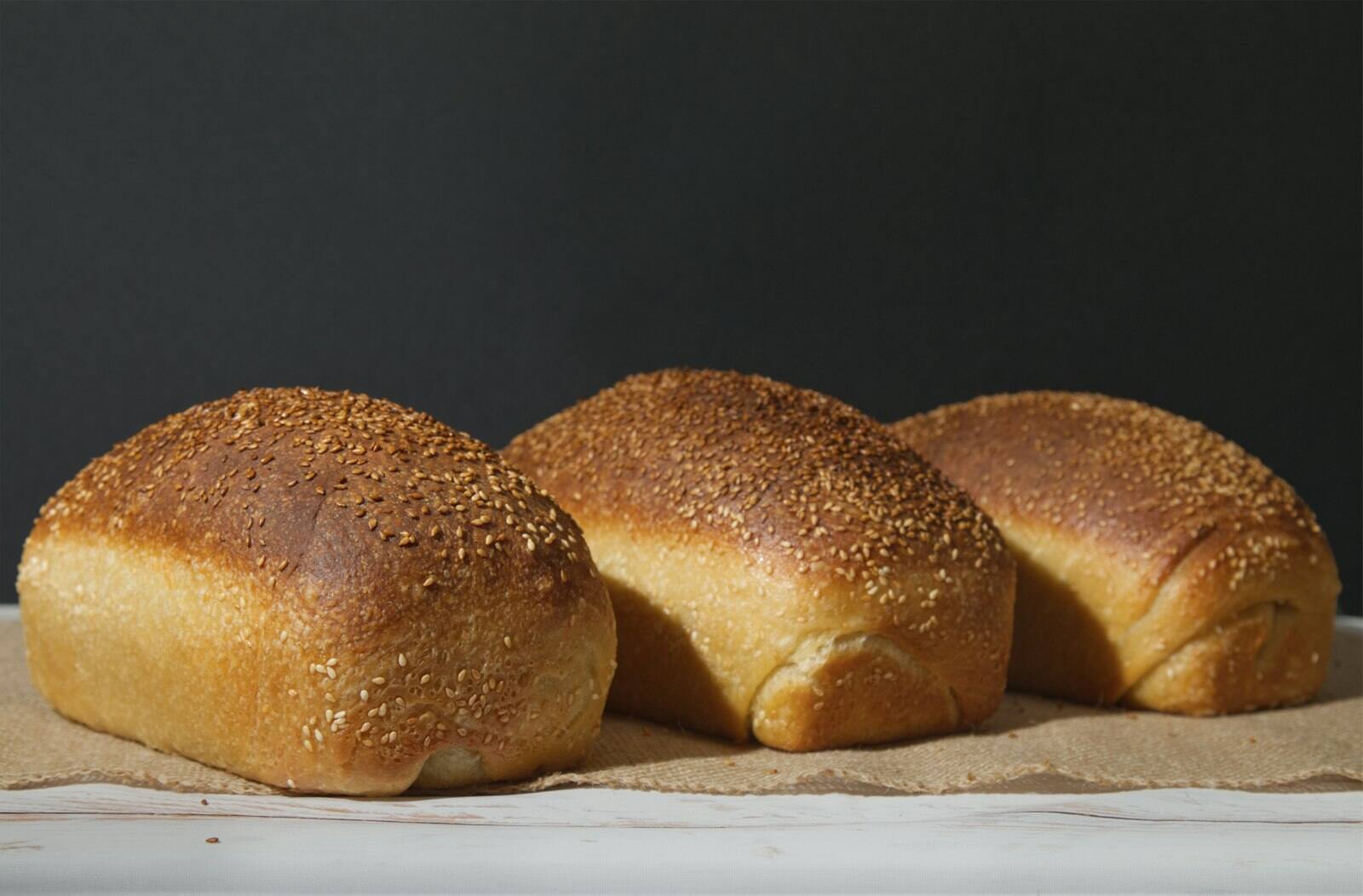Three loaves of bread on a brown paper.